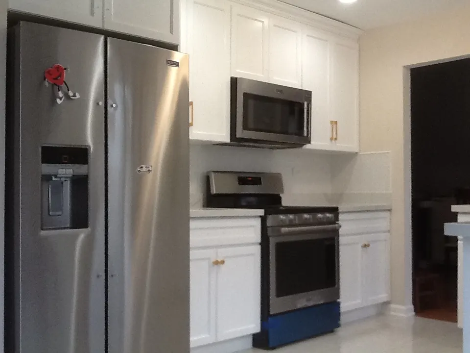 White shaker-style kitchen with golden hardware